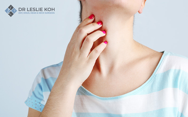 woman touching her neck in pain