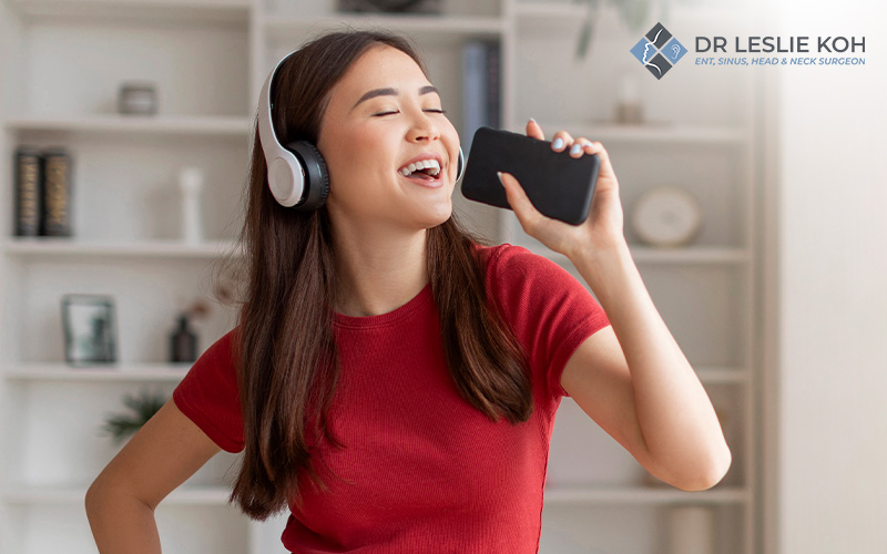 woman with headphones using her phone as microphone