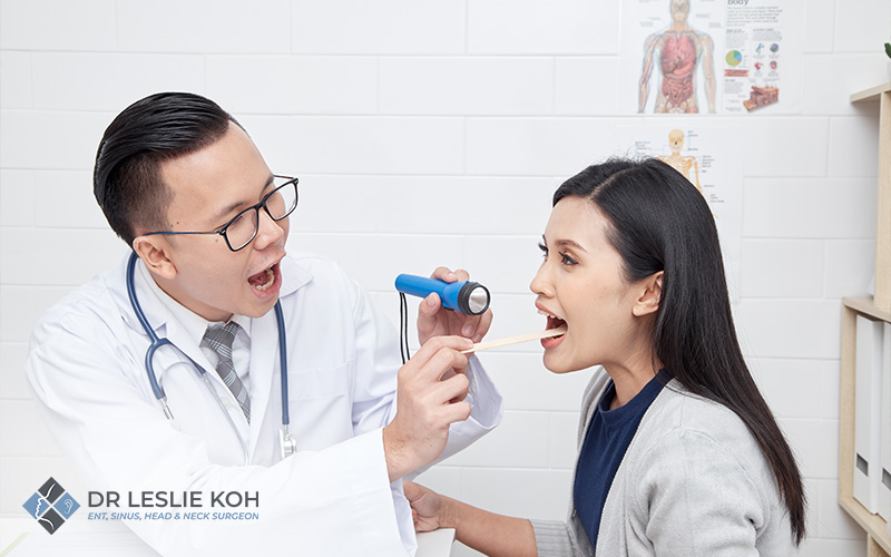 woman having her throat checked by a doctor