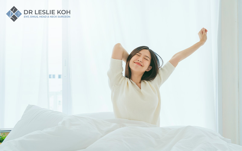 woman in bed stretching upon waking up