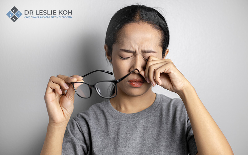 woman rubbing her face due to sinus discomfort