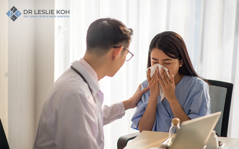 doctor making diagnosis on woman blowing her nose on tissue