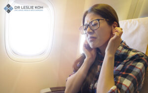Woman experiencing ear pain while flying