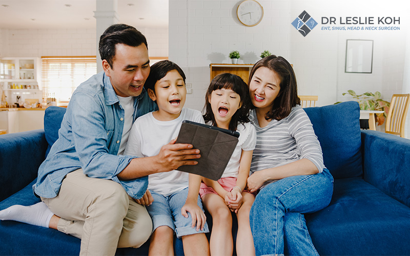 family sitting on couch watching on their tablet